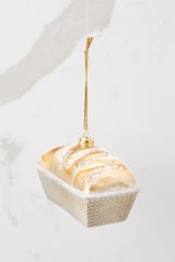 Front view of this ornament that features a gold and glitter encrusted tin of bread.