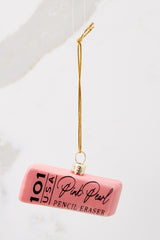 This pink ornament features a pink eraser design with writing on it. 