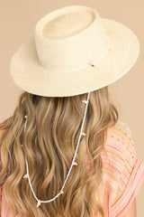 This off white hat features a shell lining and a strap with seashell detail.