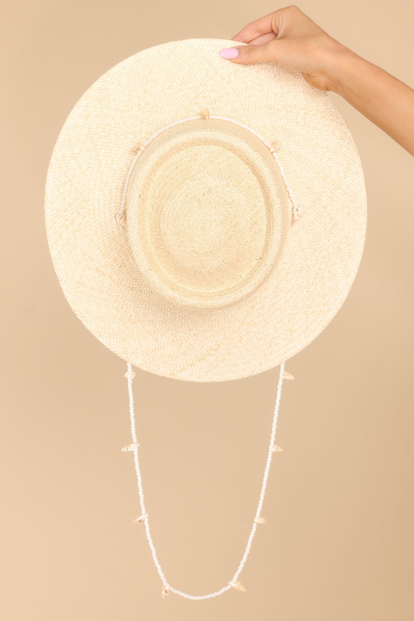 Top view of this hat that features a shell lining and a strap with seashell detail.