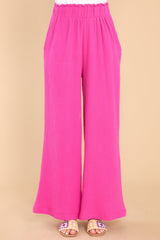 Front view of these pants that feature a high rise elastic waist, pockets at the hip, and a wide leg.