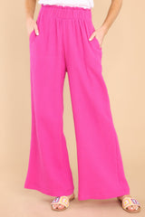 These fuchsia pants feature a high rise elastic waist, pockets at the hip, and a wide leg.