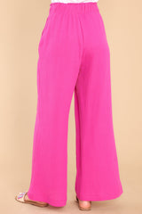 Back view of these pants that feature a high rise elastic waist, pockets at the hip, and a wide leg.
