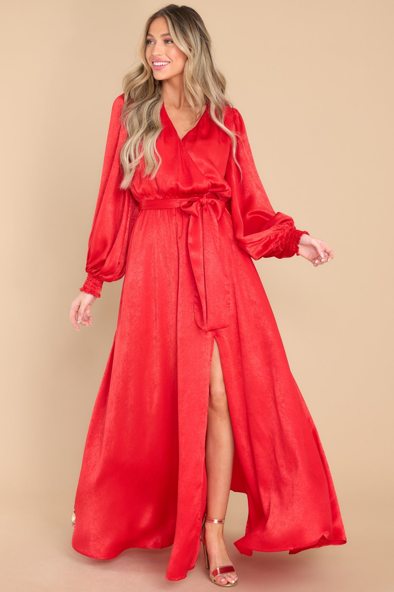 This all red dress features a v-neckline, a snap closure at the bust, puff sleeves with elastic cuffs, an elastic waist band with a removable adjustable self tie around the waist, and a slit on the side.