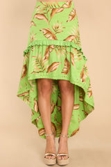 This green skirt features a high waist, zipper down the side, and a tiered flowy high low silhouette. 