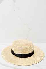 Side view of this boater hat that features a natural straw structured brim, a black bow detail gross-grain ribbon, and natural straw.