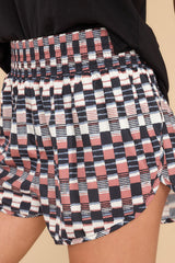 Close up view of these shorts that feature a high elastic waistband, a stretchy, fitted lining, and a fun pattern throughout.