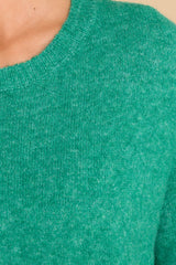 Close up view of this sweater that features a crew neckline and a soft knit material.