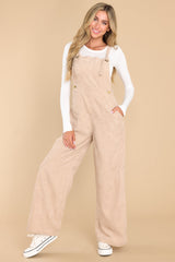 These beige overalls feature adjustable self-tie straps, four functional side pockets and two back pockets, buttons below the bust to allow for a folded look, and a corduroy texture throughout.