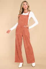 Front view of these overalls that feature adjustable self-tie straps, four functional side pockets and two back pockets, buttons below the bust to allow for a folded look, and a corduroy texture throughout.
