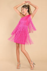 This hot pink dress features a one shoulder design, functional zipper on the side, and fringe detailing throughout with lots of movement.
