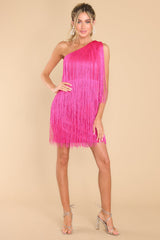 Full body view of this dress that features a one shoulder design, functional zipper on the side, and fringe detailing throughout with lots of movement.