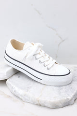 Outside view of white platform sneakers featuring white laces. 
