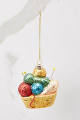Back view of this ornament that features faux balls of yarn and knitting needles with gold sparkle detailing.