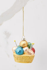This multi-colored ornament features faux balls of yarn and knitting needles with gold sparkle detailing.