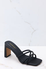 Outer-side view of these sandals that feature a textured black finish, three straps across the top of the foot, a flattened block heel, and light cushioning in the base.