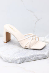 Outer-side view of these sandals that feature a textured ivory-colored finish, three straps across the top of the foot, a flattened block heel, and light cushioning in the base.