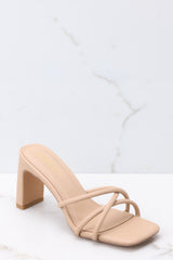 These taupe sandals feature a textured taupe-colored finish, three straps across the top of the foot, a flattened block heel, and light cushioning in the base.