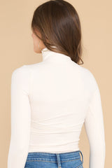 Back view of  this bodysuit that features a turtleneck design, long sleeves, a ribbed texture throughout, and thong-style bottom with a snap button closure.
