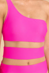 Close up view of this one-piece that features a one shoulder neckline, mesh cutouts around the waist, and removeable padding.