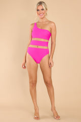 Full body view of this one-piece that features a one shoulder neckline, mesh cutouts around the waist, and removeable padding.