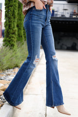 Side view of these jeans that feature  light distressing throughout, wide legs, functional pockets, and a standard zipper and button closure.