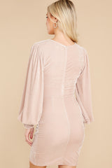 Back view of this dress that features a wrap front, cuffed long sleeves, and a back zipper.