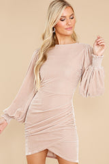 This taupe dress features a wrap front, cuffed long sleeves, and a back zipper.
