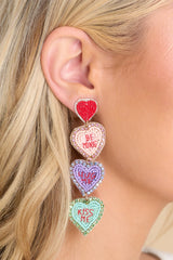 Close up view of these heart-shaped dangle earrings that feature beaded detailing, a felt back, and a secure post backing.