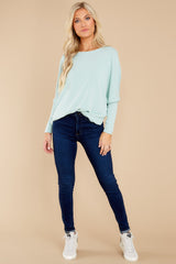 Full body view of this pull over top that features a round neckline and long dolman sleeves.