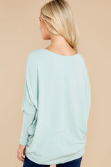 Back view of this pull over top that features a round neckline, long dolman sleeves, and a slight high low hem line.