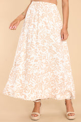 This ivory and beige skirt features a high elastic waistband, pockets at the hip, and is flowy throughout.