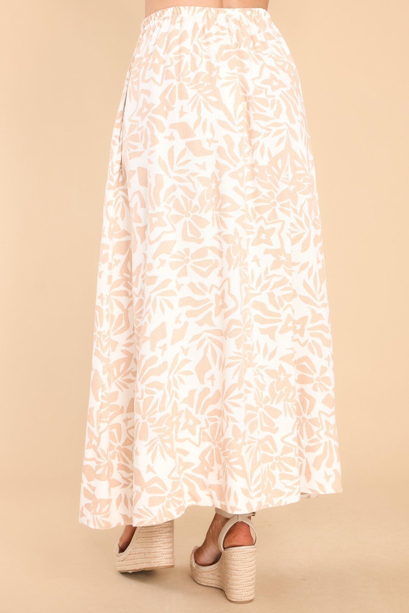 Back view of this skirt that features a high elastic waistband, pockets at the hip, and is flowy throughout.
