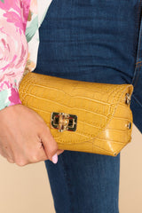 This honey yellow snake print small bag features a leather body, gold-colored hardware, wooden turn-lock closure, detachable curb chain strap that drops 23