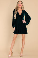 Full body view of this dress that features a plunge v-neckline, balloon elastic cuff sleeves, an A-line flared out bottom, and a back zipper hook and eye closure.