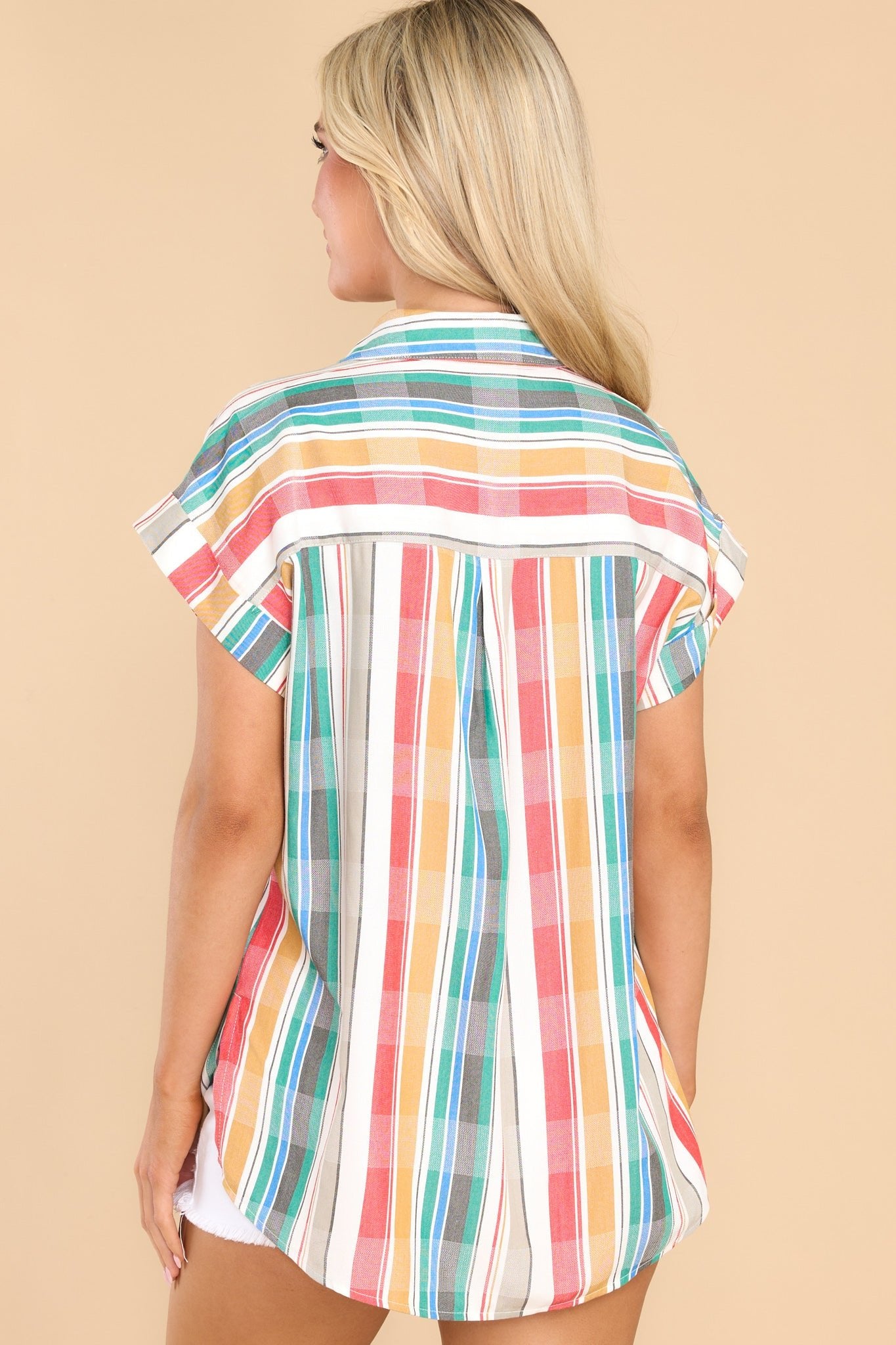 Back view of this top that features a collared neckline, functional buttons down the bodice, cuffed short sleeves, and one functional breast pocket.