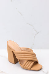 Close up view of these heels that feature a square heel, two crossed straps across the top of the foot, and a chunky block heel.