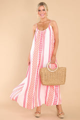 This pink and white dress features a scoop neckline, non-adjustable straps, and a flowy fit.