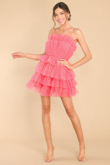 Full body view of this dress that features tulle ruffling with small white polka dots throughout.