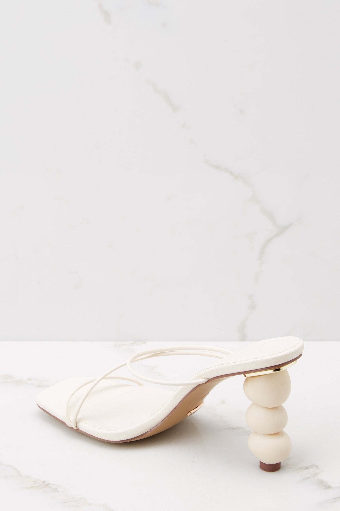 Inner-side view of these heels that feature a square toe and straps across the top of the foot.
