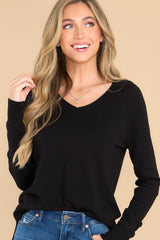 This all black top features a slight v-neckline with a raw hemline, 3.5