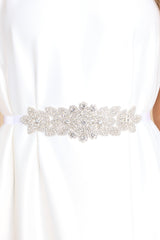Close up view of this belt that features a crystal iridescent flower centerpiece, and a self-tie ribbon closure. 