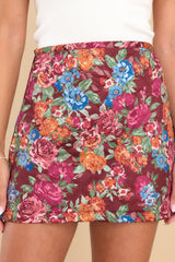 This burgundy floral print skirt features a high-waist, zipper closure with a loop button, and a quilted puffer design. 